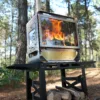 Table Master Ultra wood stove burning beside a tent in an outdoor camp setting