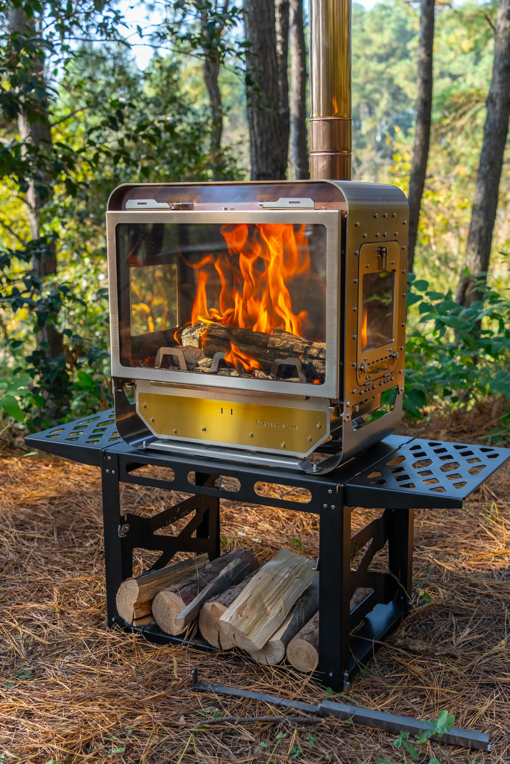 Table Master Ultra wood stove burning on its folding stand in a forest camp