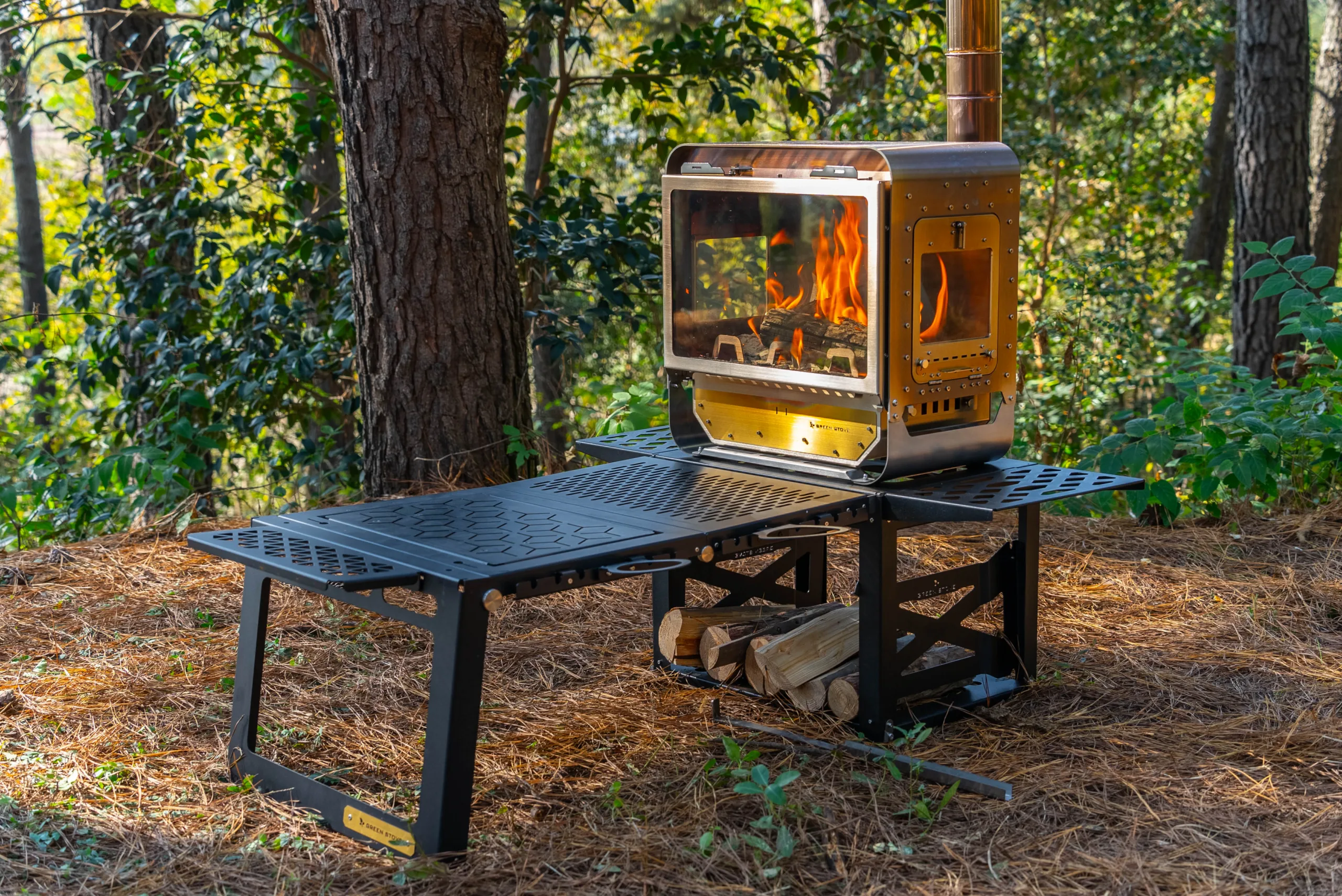 Table Master Ultra wood stove with folding side shelves in a daytime forest camp